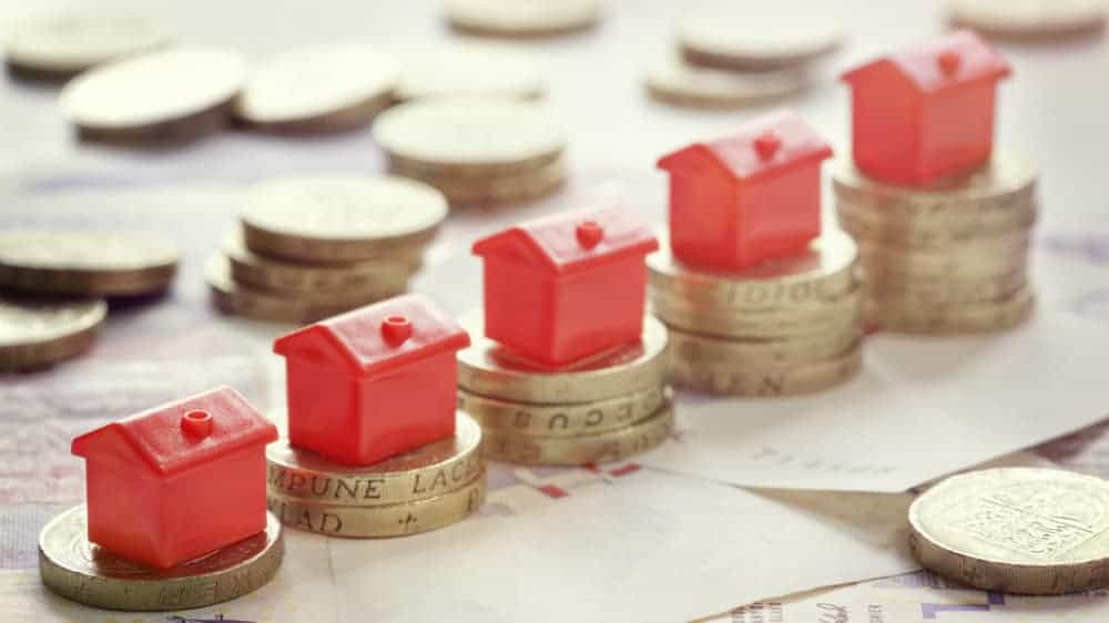 Models of houses on top of pound coins