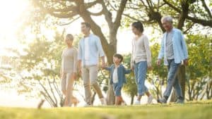 Three generation happy family walking outdoors in park