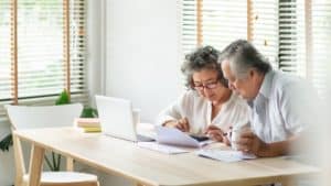 Stressed Asian Senior Couple using calculator and calculate family budget