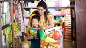 Mother with son looking at product while shopping at supermarket