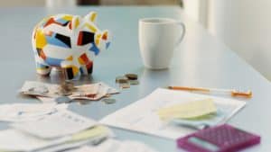 Piggybank, British Currency, Calculator, Receipts and a Mug on a Table
