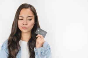 Woman looking sideways at credit card