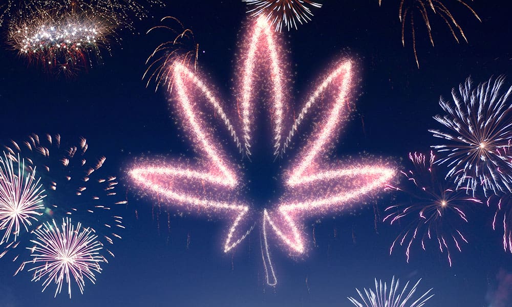 The outline of a hemp leaf, created with fireworks, in the night sky.