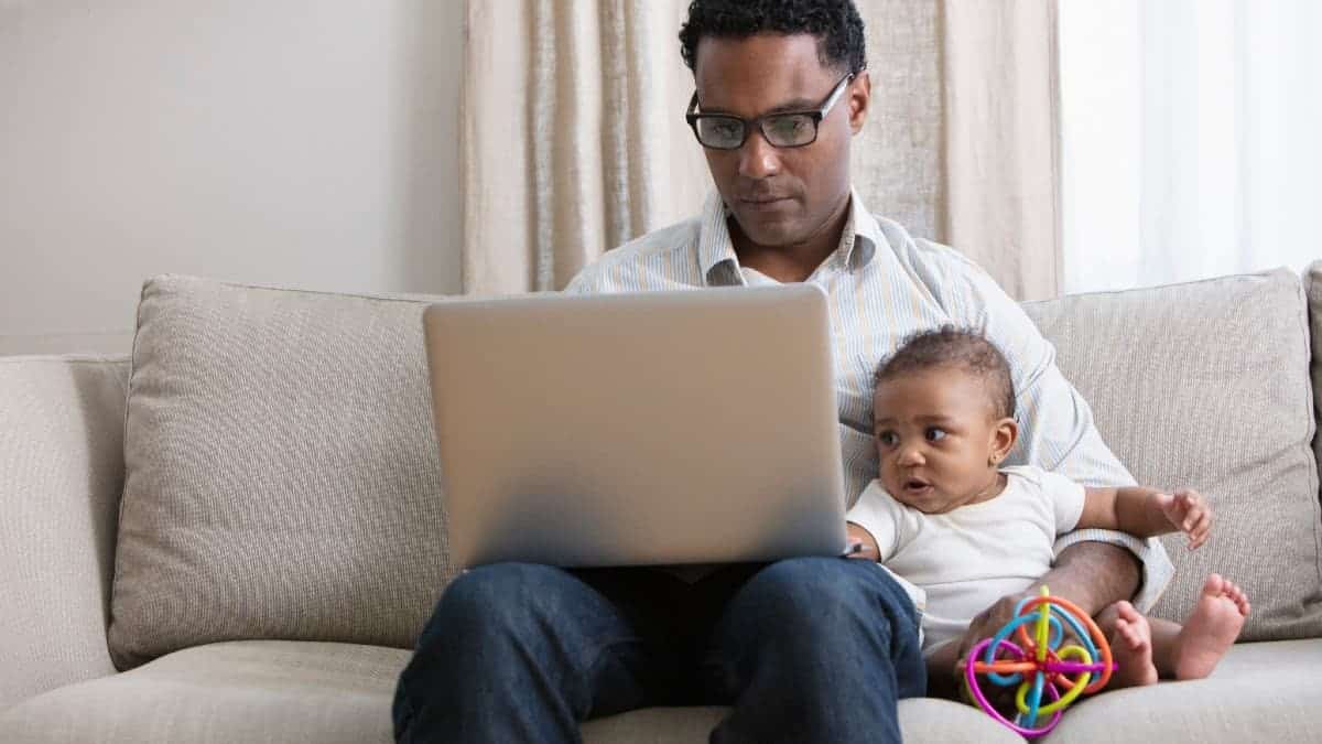 Father working from home and taking care of baby.