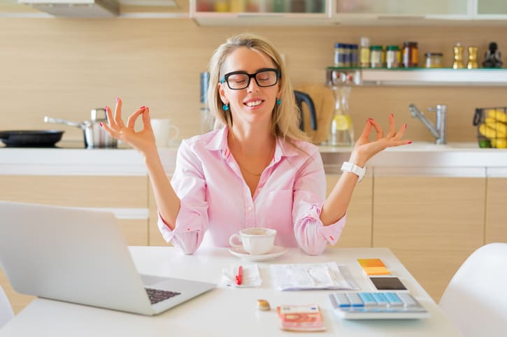 Financially free and calm woman sitting in kitchen