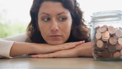 Woman looking at a jar of pennies