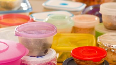 Several plastic food containers with leftovers.