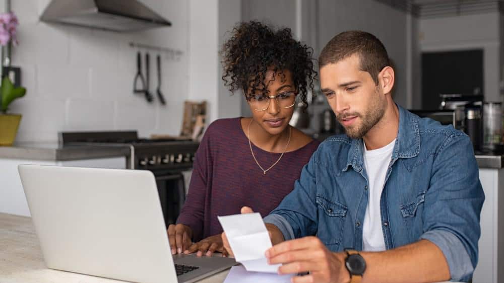 Young casual man and girl using laptop while looking at invoice and plan the budget to save.