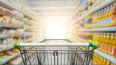 Supermarket aisle with empty green trolley