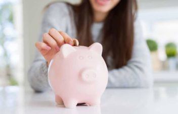 A coin being dropped into a piggy bank