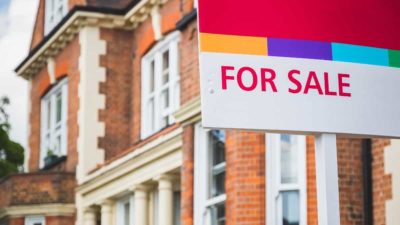 For Sale sign displayed outside a terraced house