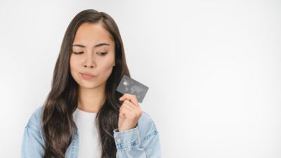 Woman looking sideways at credit card