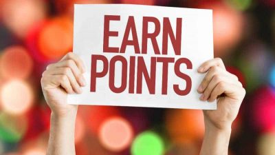 Hands holding up a sign saying Earn Points