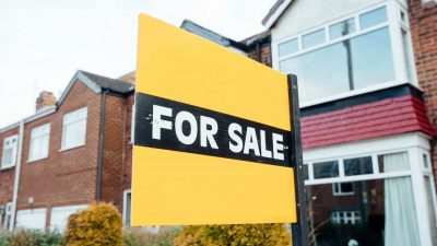 'For Sale' sign outside of a terraced house in the UK