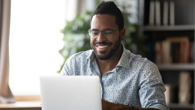 Man smiling and working on laptop