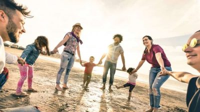 Family holding hands in a circle on a beach