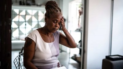 Mature woman with headache at home