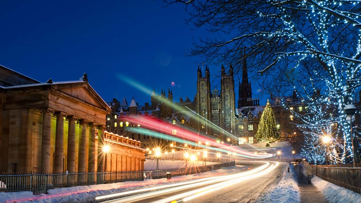 Light trails from traffic moving down The Mound in central Edinburgh, Scotland during December