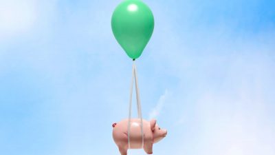 Piggy bank being carried by balloon