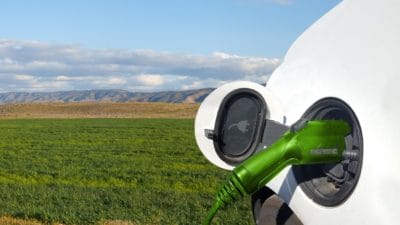 Close up view of Electric Car charging and field background