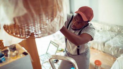 Close up of a young man renovating and painting the house