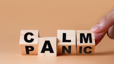 Hand flipping wooden cubes for change wording" Panic " to " Calm".