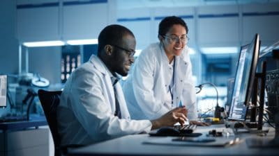 Engineer Project Manager Talks With Scientist working on Computer