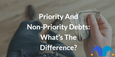 Man holding money in hand with the text “Priority and non-priority debts what’s the difference?” and The Motley Fool jester cap logo