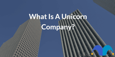 Skyscrapers street level view with the text “What is a unicorn company?” and The Motley Fool jester cap logo