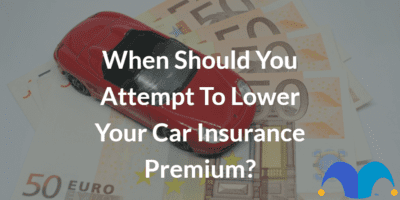 Toy car on money with the text “When should you attempt to lower your car insurance premium?” and The Motley Fool jester cap logo
