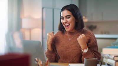 Young brown woman delighted with what she sees on her screen