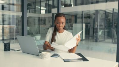 Shot of a young Black woman doing some paperwork in a modern office