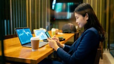 Happy young female stock-picker in a cafe