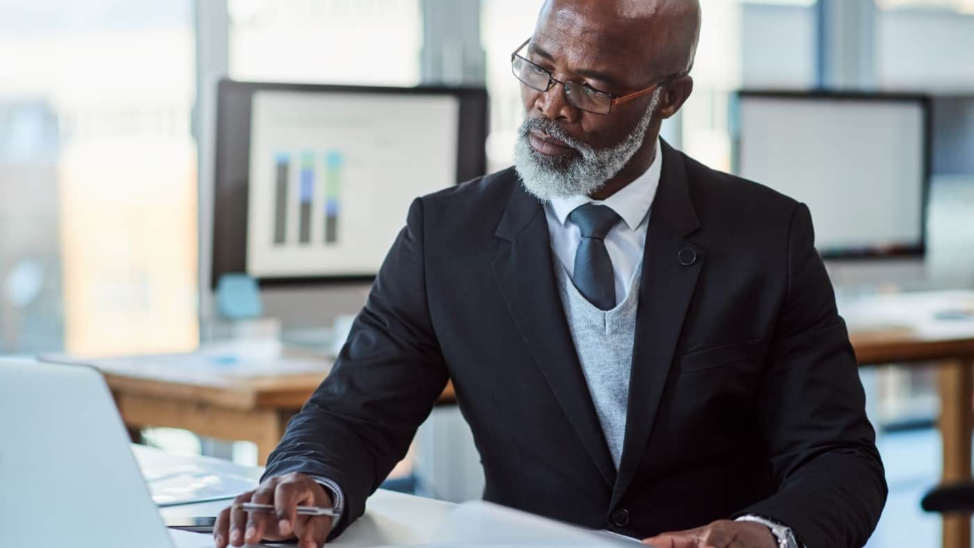Smartly dressed middle-aged black gentleman working at his desk