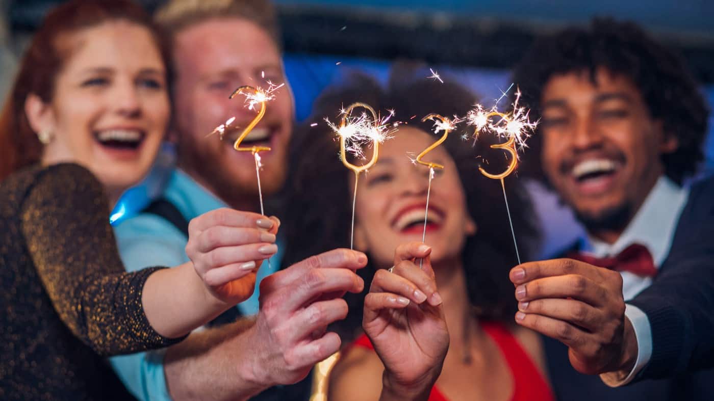 Young happy people looking at sparklers in their hands on New Year's Eve