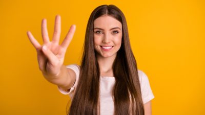 Young Caucasian woman holding up four fingers