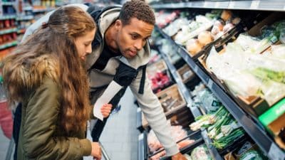 Girl buying groceries in the supermarket with her father.