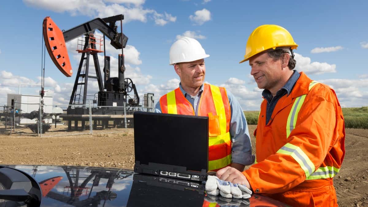 Δύο λευκοί εργάτες που εργάζονται επί τόπου σε μια εξέδρα πετρελαίου