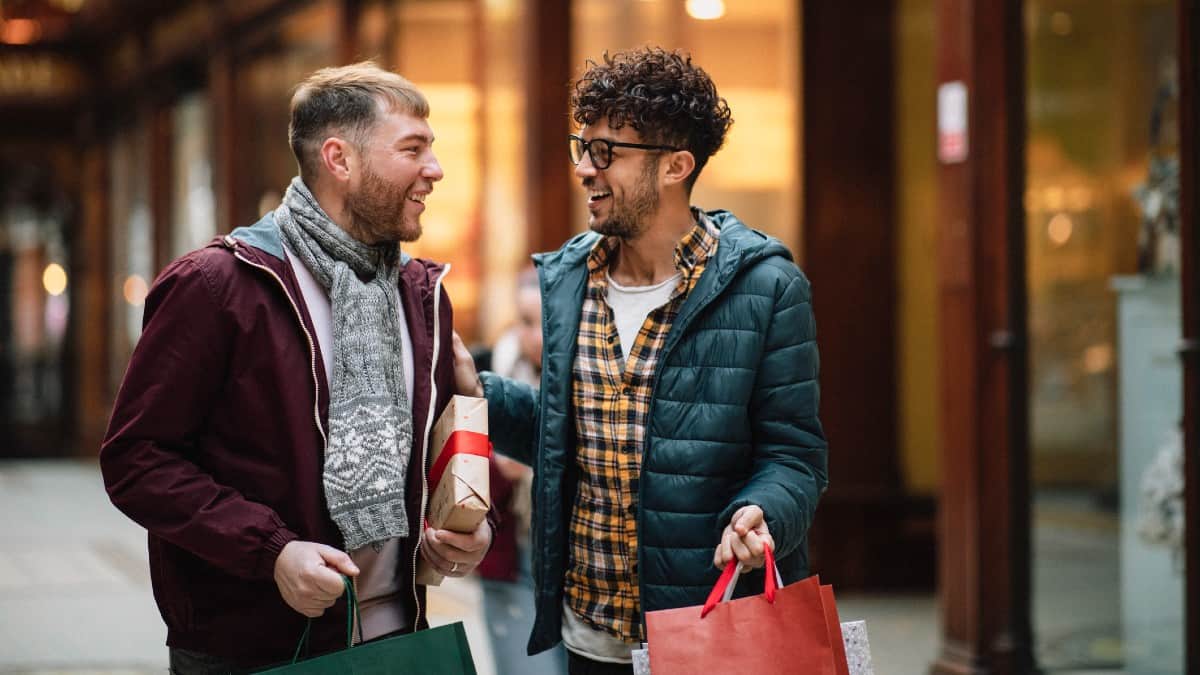 Two gay men are walking through a Victorian shopping arcade