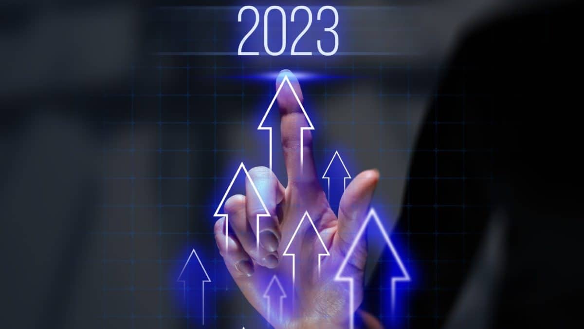 2023 concept with upwards-facing arrows overlaid on a hand with one finger raised, pointing up