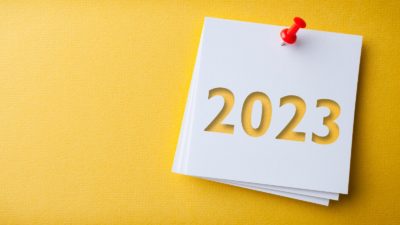 White note with '2023' written on, pinned to a yellow background