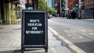The words "what's your plan for retirement" written on chalkboard on pavement somewhere in London