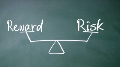 Chalkboard representation of risk versus reward on a pair of scales