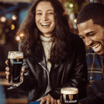 Two people socialising and drinking Guinness.