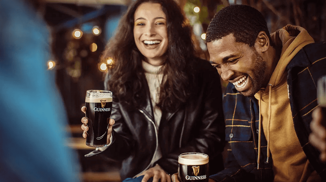 Two people socialising and drinking Guinness.